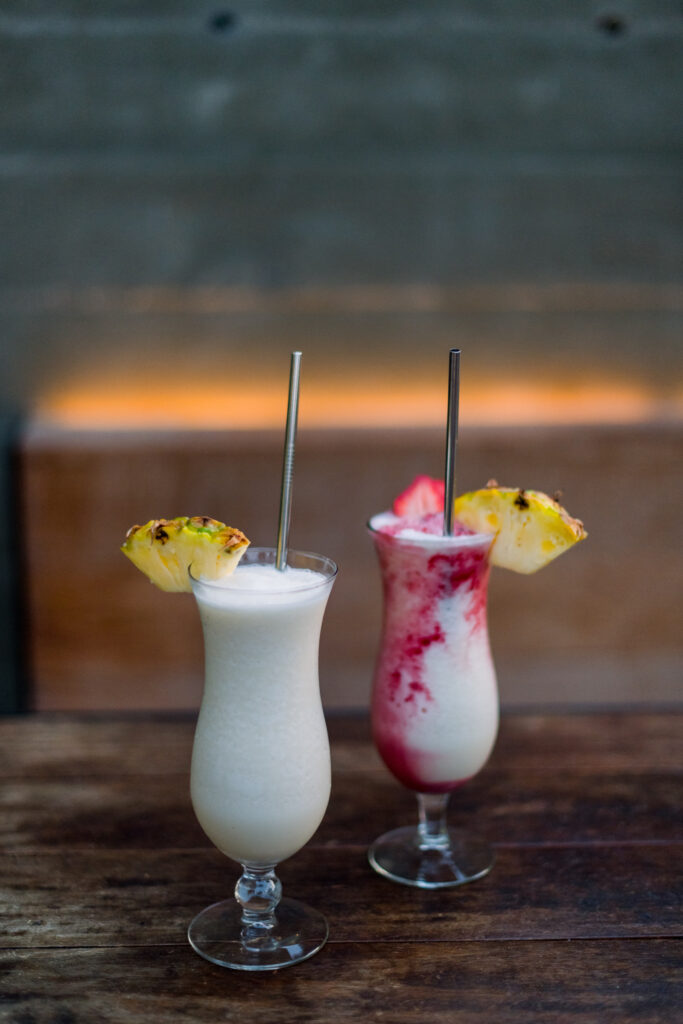 A Pina Colada and Lava Flow stand on a wooden table